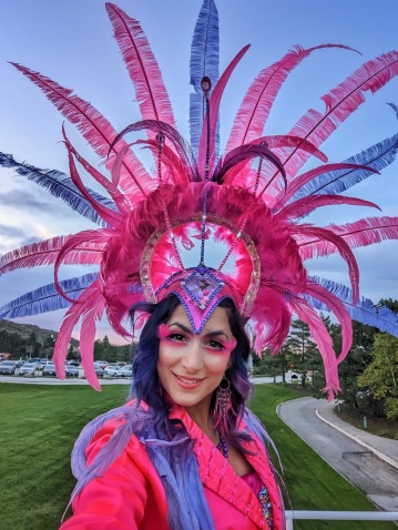 pink and purple feather headpiece Hala on stilts